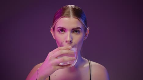Wunderschöne-Kaukasische-Frau-Trinkt-Wasser-Aus-Transparentem-Glas,-Dunkler-Hintergrund
