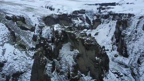 Iceland-Gorge-with-High-Cliff-Rocks-in-a-Ravine-in-Iceland-Covered-with-Snow-and-Ice