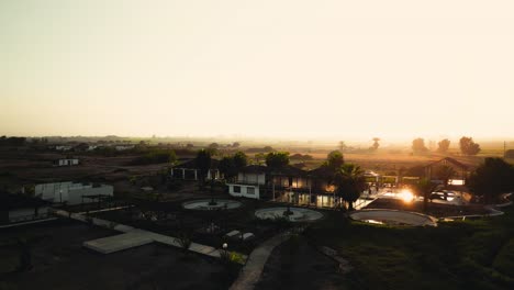Beautiful-view-of-a-house-with-bungalows-and-a-pool-by-the-sea-at-sunrise