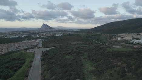 4k-Drohne-Steigt-Bei-Sonnenaufgang-Aus-Spanien-Auf-Und-Blickt-Auf-Gibraltar-Am-Horizont-Mit-Einigen-Wolken