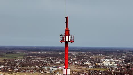 Aerial-drone-rotates-communication-tower-landmark-around-rural-countryside-field