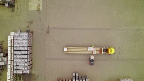 Aerial-View-of-Yellow-Semi-Truck-Being-Loaded-by-Forklifts-in-Logistics-Yard