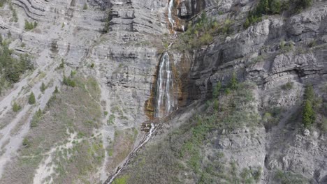 Aerial-push-in-and-over-Bridal-Veil-Falls-in-American-Fork-Canyon,-Utah-during-spring