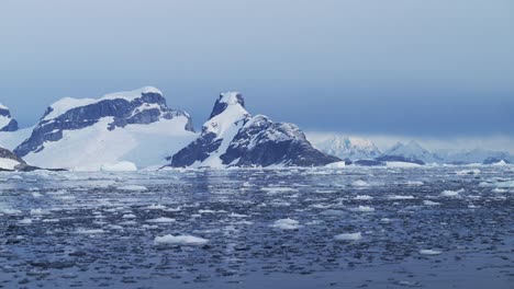 Aerial-drone-shot-of-Antarctica-Scenery,-Global-Warming-Visible-with-Melting-Snow,-Climate-Change-with-Ice-Melted-from-the-Mountains,-Antarctic-Peninsula-Landscape-in-Winter-Weather,-Southern-Ocean