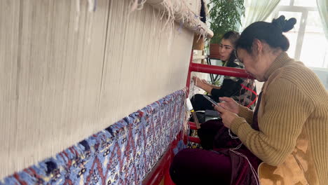 TWO-Unidentified-female-weaver-knotting-a-handmade-carpet