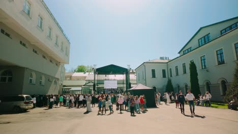 Courtyard-in-Latvia-with-student,-pupil,-crowd,-audience-attending-public-concert-in-spring-in-Daugavpils-city