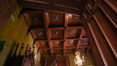 Small-Library-in-Trakošćan-Castle-,-Croatia,-showcasing-an-ornate-coffered-ceiling-and-chandelier