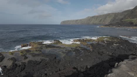 Gente-Explorando-Rocas-Volcánicas-En-La-Playa-De-Mosteiros,-Sao-Miguel-Con-Olas-Rompiendo,-Vista-Aérea