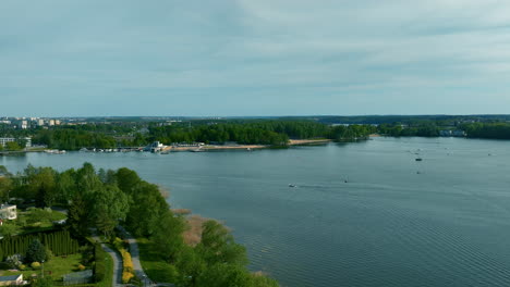A-wide-shot-of-Ukiel-Lake,-showing-the-urban-area-of-Olsztyn-in-the-background