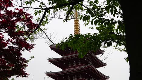 Beautiful-pagoda-at-Senso-ji-Shrine-in-Tokyo,-Japan-framed-by-trees