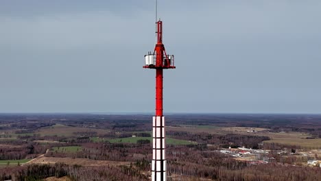 Luftdrohne-Fliegt-über-Der-Isolierten-Lettischen-Landschaft-Mit-Rotem-Turm-Auf-Dem-Land