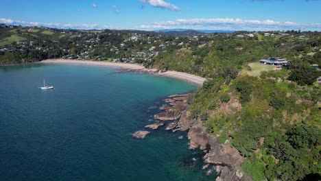 Palmenstrand-Mit-Felsen-Und-Grünem-Laub-In-Der-Mawhitipana-Bay,-Auckland,-Neuseeland