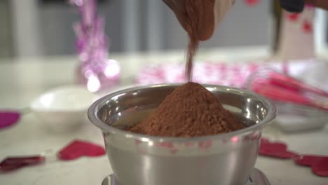 Nahaufnahme-Von-Kakaopulver,-Das-In-Eine-Schüssel-Mehl-Gegeben-Wird,-Um-Daraus-Einen-Besonderen-Valentinstagskuchen-Zu-Machen,-Veganer-Schokoladenkuchen-Ohne-Eier,-Auf-Pflanzlicher-Basis-Und-Ohne-Milchprodukte