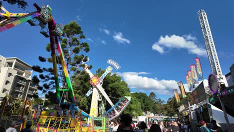 Large-crowd-attending-at-Paniyiri-Greek-Festival-in-Brisbane,-Australia-enjoying-thrill-riders