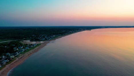 Sonnenuntergang-über-Strandhäusern-Mit-Farben,-Die-Sich-In-Den-Meereswellen-Spiegeln,-Und-Ferienhäusern-Entlang-Der-Atlantikküste-Von-Neuengland