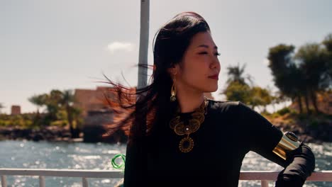 Elegante-Asiatische-Frau-Auf-Einer-Bootsfahrt-In-Ägypten-Genießt-Warme-Sonnenstrahlen-An-Einem-Windigen-Tag