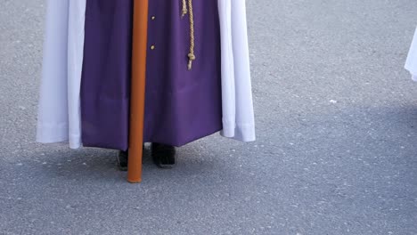 This-clip-features-a-person-in-a-purple-and-white-tunic-with-a-tall,-pointy,-face-covering-headdress-providing-a-unique-glimpse-into-religious-practices-and-ceremonies