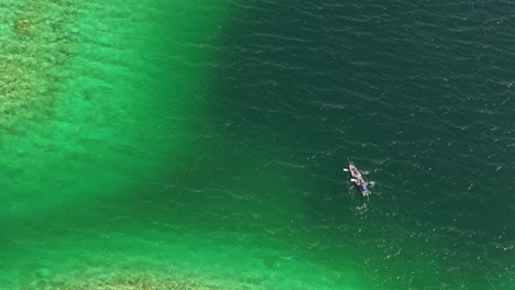 Observing-from-above-as-a-kayaking-boat-floating-the-the-waters-of-Eibsee-in-Grainau,-Germany,-in-a-top-down-aerial-view