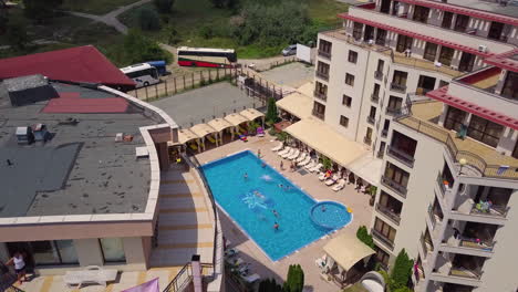 Aerial-view-of-swimming-pool-in-hotel-complex-with-kids-playing