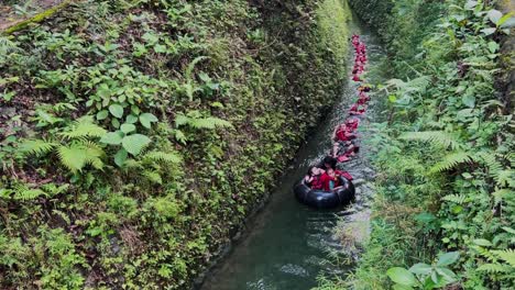 Un-Grupo-De-Participantes-De-Rafting-Usan-Chalecos-Salvavidas-Y-Flotan-Juntos-En-Fila-En-El-Río-De-Montaña