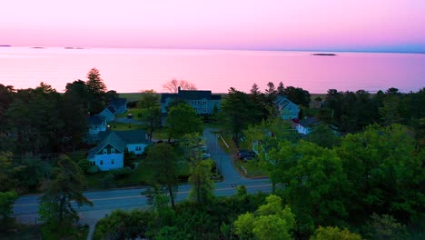 Leuchtend-Violetter-Sonnenuntergang-über-Strandhäusern-Mit-Farben,-Die-Sich-In-Den-Meereswellen-Spiegeln,-Und-Ferienhäusern-Entlang-Der-Atlantikküste-Von-Neuengland