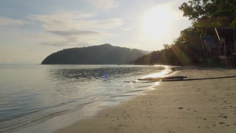 Der-Goldene-Sand-Der-Insel-Kri-Mit-Seinen-Kleinen-Holzhütten,-Eingebettet-In-Den-Raja-Ampat-Archipel-In-Indonesien,-Schwelgen-Sie-Im-Warmen-Schein-Der-Untergehenden-Sonne