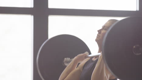 Slomo-side-view-of-female-athlete-doing-clean-and-jerk-with-barbell,-CrossFit