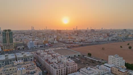 Rising-aerial-shot-over-Jeddah-city-in-Saudi-Arabia-at-sunset-showing-the-golden-glow-of-the-sun-over-the-city-buildings