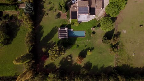 Aerial-establishing-shot-of-a-villa-in-France-with-solar-panels-and-a-private-pool