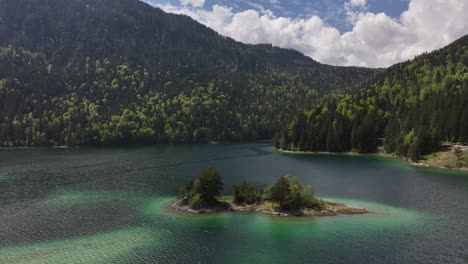 The-crystal-clear-eibsee-lake-in-grainau,-germany-surrounded-by-lush-forests-and-rugged-mountains,-aerial-view
