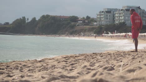 Männlicher-Rettungsschwimmer-Zu-Fuß-Am-Strand-Entlang