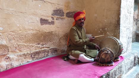 Traditioneller-Rajasthani-Mann-Spielt-Tabla-An-Der-Seite-Der-Festung-In-Der-Stadt-Jodhpur