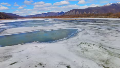 A-large-mountain-river-thaws-from-ice-in-sunny-spring-from-a-4k-drone