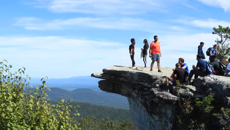 Gente-Disfrutando-De-La-Vista-Desde-Lo-Alto-De-McAfee-Knob-En-Virginia,-Algunas-Personas-Relajándose-Y-Almorzando-Después-De-La-Caminata-Por-El-Sendero-De-Los-Apalaches.