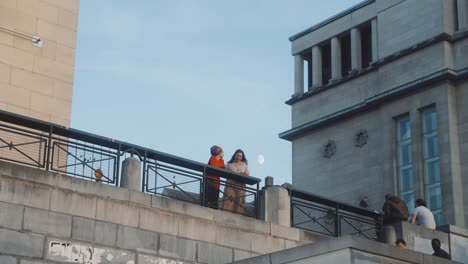 Sonnenuntergang-Auf-Dem-Mont-Des-Arts-In-Brüssel,-Belgien,-Mit-Menschen,-Die-Auf-Treppen-Gehen,-Und-Ein-Paar-Frauen,-Die-Sich-Während-Der-Pandemie-Zwanglos-Und-Mit-Glücklichen-Gesichtern-Unterhalten