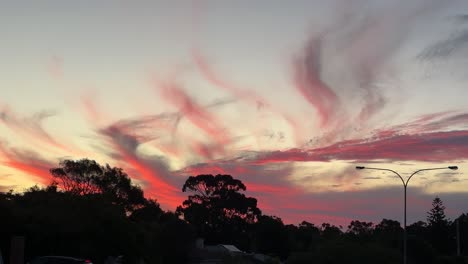 Wispy-orange-sunset-Australian-suburb-silhouetted-with-gum-trees-and-light-pole