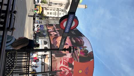 Vídeo-Vertical-De-La-Entrada-De-La-Estación-De-Metro-Piccadilly-Circus-En-Londres,-Inglaterra,-En-Una-Mañana-Soleada