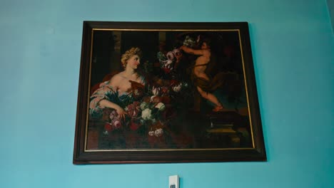 Classic-oil-painting-of-a-baroque-scene,-elegantly-displayed-against-a-vivid-blue-wall-in-Trakošćan-Castle,-Croatia