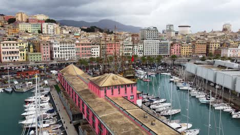 Genoa's-vibrant-port-and-colorful-buildings-under-cloudy-skies,-aerial-view