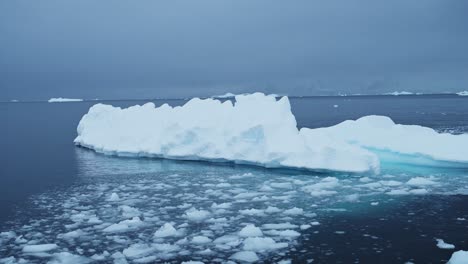 Toma-Aérea-De-Drones-De-Icebergs-Antárticos,-Formaciones-De-Hielo-De-Hermosos-Icebergs-Invernales-Flotando-En-El-Agua-Azul-Del-Océano-Austral-En-La-Península-Antártica-En-Una-Excursión-En-Barco-Zodiac