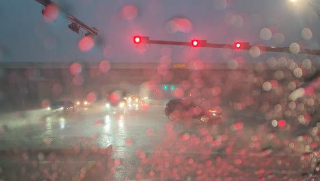 This-video-shows-traffic,-moving-through-an-intersection,-while-the-beginnings-of-the-storm-are-coming-through-the-town