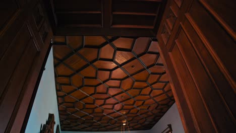 Upward-view-of-a-uniquely-patterned-wooden-hexagonal-ceiling-at-Trakošćan-Castle,-flanked-by-rich-wooden-door-frames