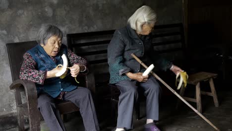 Two-old-lady-friends-sharing-a-funny-moment-eating-a-banana-part2