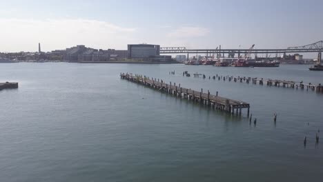 Aerial-Overlooking-Abandoned-Piers-On-Mystic-River-With-Memorial-Bridge,-Boston