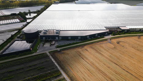Industrial-facility-with-massive-greenhouses,-aerial-drone-view