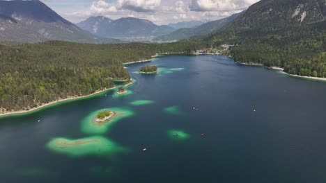 Aerial-view-of-Eibsee,-Grainau,-Germany,-showcasing-turquoise-waters,-forested-shores,-and-mountain-backdrop