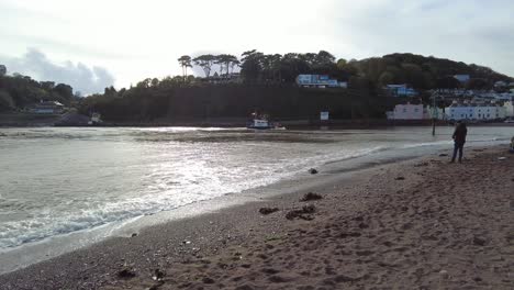 Teignmouth-Beach-With-People-Fishing-And-Small-Trawler-Boat-Coming-In-Background