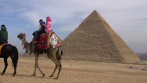tourist-riding-camel-in-front-of-pyramids-of-Egypt