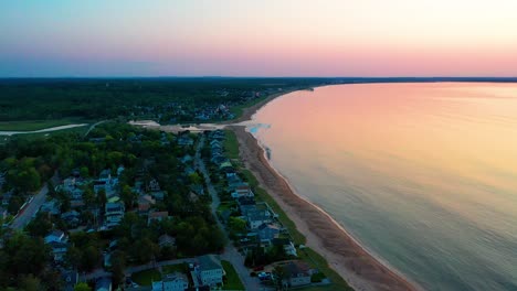 Luftaufnahme-Eines-Wunderschönen-Sonnenuntergangs-Am-Strand-In-Saco,-Maine,-Mit-Farben,-Die-Sich-In-Den-Meereswellen-Widerspiegeln,-Und-Ferienhäusern-Entlang-Der-Atlantikküste-Von-Neuengland