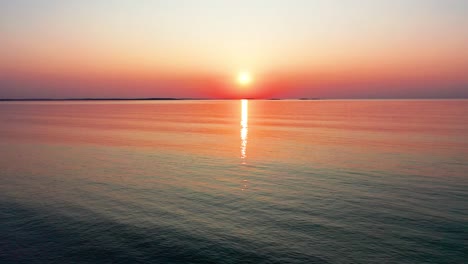 Aerial-Drone-View-of-Colorful-Beach-Sunset-in-Saco,-Maine-with-Bright-Colors-Reflecting-off-Calm-Rippling-Ocean-Waves-Along-the-New-England-Atlantic-Coastline